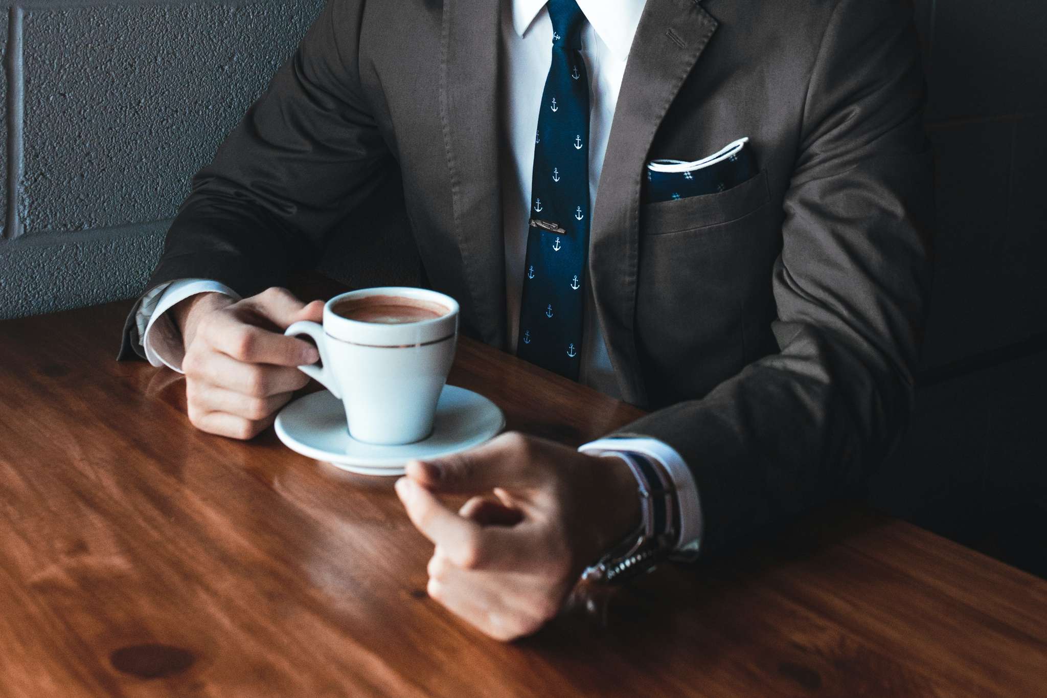 Nöjd företagsledare njuter av sin kopp kaffe i fin kostym